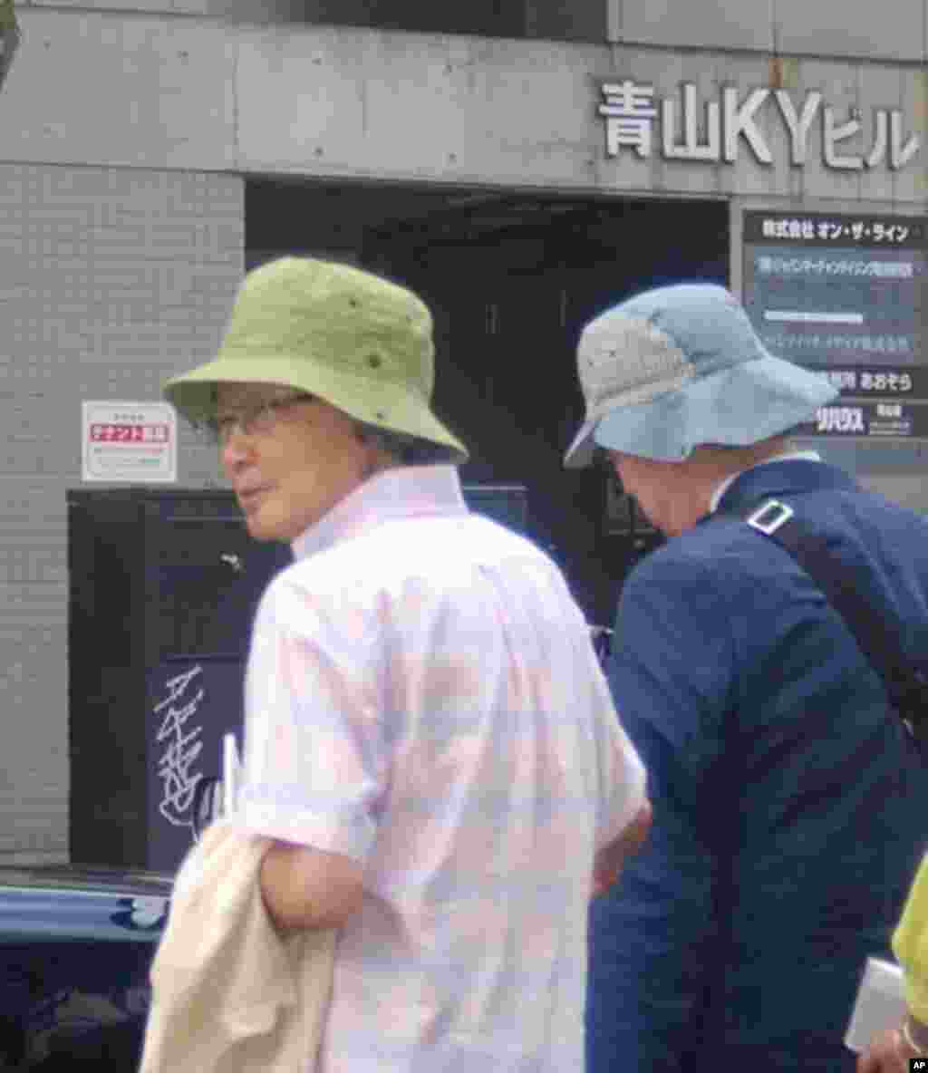 Novelist Kenzaburo Oe (right), 76, being escorted from the march after dropping out partway on a hot and humid day.