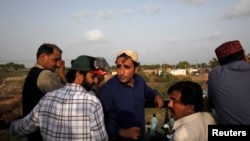 Bilawal Bhutto Zardari, chairman of the Pakistan People's Party, wearing a Sindhi topi hat, speaks to party workers on the roof of his bullet-proof bus, during a campaign rally ahead of general elections in District Thatta, Pakistan, July 2, 2018.