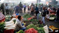 Indians buy vegetables early morning at a whole sale market in Lucknow, India , Jan. 27, 2020. Rising food and vegetable prices have taken retail inflation for the month of December to its highest level in over 5 years, according to news reports. 