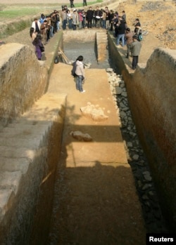 People look at the foot of the ruins of an ancient city wall in Liangzhu, Zhejiang province November 29, 2007. REUTERS/China Daily