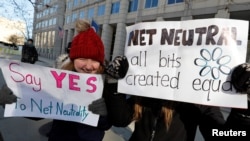 FILE - Net neutrality advocates rally in front of the Federal Communications Commission ahead of a vote to repeal net neutrality rules in Washington, Dec. 13, 2017.