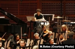 Mason Bates 'plays' the computer with the San Francisco Symphony for the world premiere of his symphony, The B-Sides, May 2009.