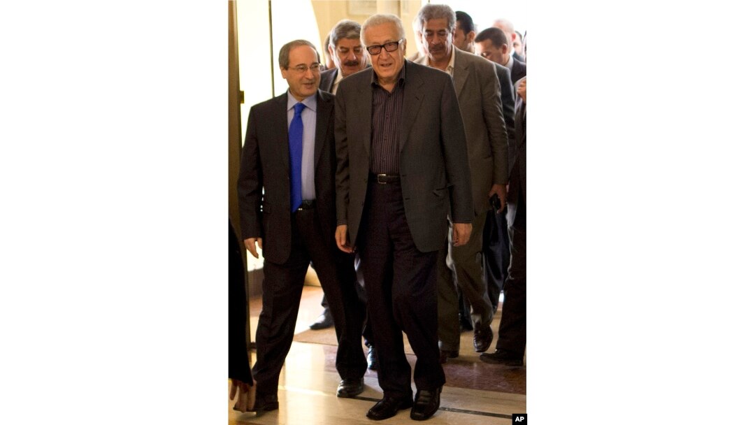 U.N.-Arab League envoy Lakhdar Brahimi (R) and Deputy Syrian Foreign Minister Faisal Mekdad arrive to a hotel surrounded by security, Oct. 28, 2013 in Damascus, Syria.