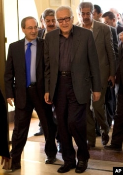 U.N.-Arab League envoy Lakhdar Brahimi (R) and Deputy Syrian Foreign Minister Faisal Mekdad arrive to a hotel surrounded by security, Oct. 28, 2013 in Damascus, Syria.