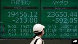 Papan saham elektronik di sebuah perusahaan sekuritas di Tokyo, menunjukkan indeks Nikkei 225 dan New York Dow Jepang, Selasa, 21 April 2020.