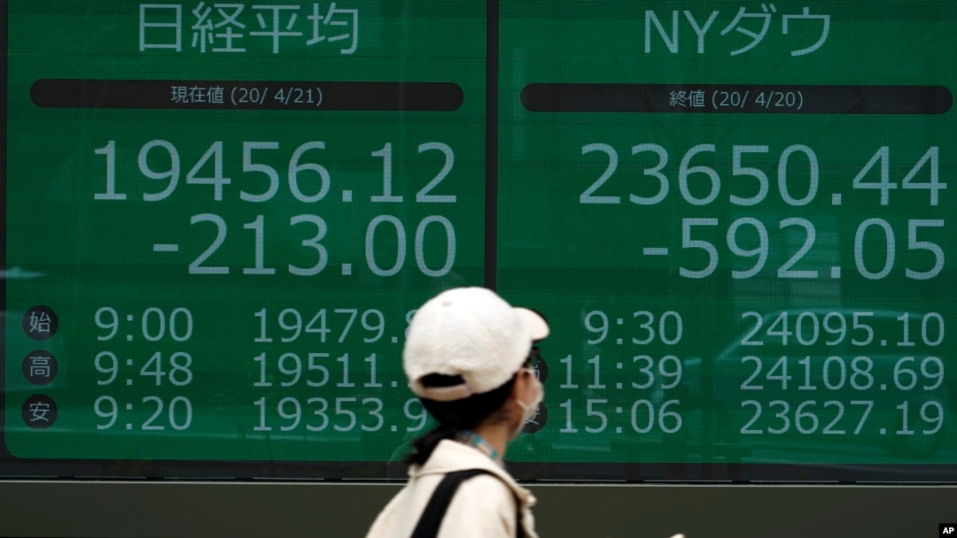 Papan saham elektronik di sebuah perusahaan sekuritas di Tokyo, menunjukkan indeks Nikkei 225 dan New York Dow Jepang, Selasa, 21 April 2020.