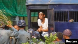 Seorang demonstran mahasiswa keluar dari kendaraan penjara setelah dikirim ke pengadilan Letpadan (11/3). (Reuters/Soe Zeya Tun)