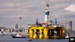 FILE - The Royal Dutch Shell oil drilling rig Polar Pioneer is towed toward a dock in Elliott Bay in Seattle. Royal Dutch Shell reported a third quarter loss of $7.4 billion, Oct, 29, 2015, as it re-organized and canceled projects, including drilling in Alaska, to cope with the plunge in oil prices.