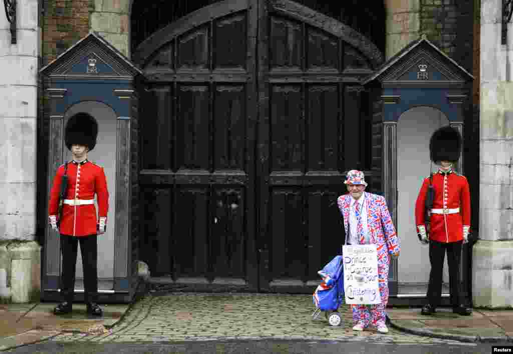 A royal fan stands outside St. James's Palace before the christening of Prince George in London, Oct. 23, 2013. 