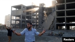 A Palestinian policeman loyal to Hamas reacts in front of a building that was hit in an Israeli airstrike in Gaza City, July 14, 2018. 