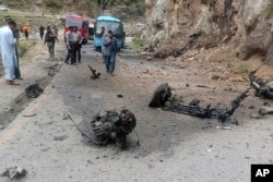 FILE - Police officers analyse   the tract  of termination   bombing astatine  a road  successful  Shangla, territory  successful  the Pakistan's Khyber Pakhtunkhwa province, March 26, 2024. The onslaught  killed 5  Chinese nationals and their Pakistani driver, constabulary  and authorities  officials said.