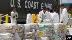 FILE - U.S. Coast Guard crew members unload roughly 7.5 tons of cocaine, in Miami Beach, Florida, which was seized from a submarine-like craft off the Caribbean Coast of Honduras, Aug. 2, 2011.