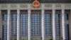 A man with a face mask walks past the Great Hall of the People, as the country is hit by an outbreak of the novel coronavirus, in Beijing, Feb. 19, 2020. 