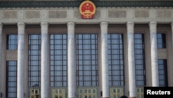 A man with a face mask walks past the Great Hall of the People, as the country is hit by an outbreak of the novel coronavirus, in Beijing, Feb. 19, 2020. 