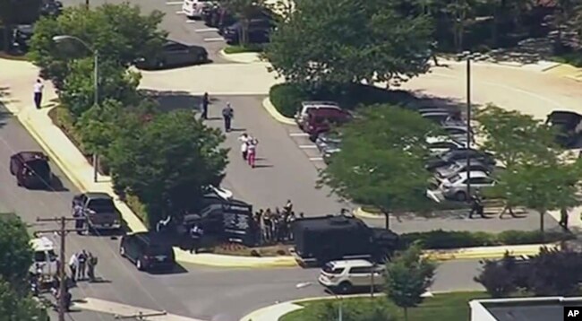 In this frame from video, people leave the Capital Gazette newspaper in Annapolis, Md., after multiple people had been shot, June 28, 2018.