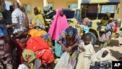 Para perempuan dan anak-anak yang diselamatkan oleh tentara Nigeria dari ekstremis Boko Haram tiba di markas militer di Maiduguri, Nigeria (30/7). (AP/Jossy Ola)