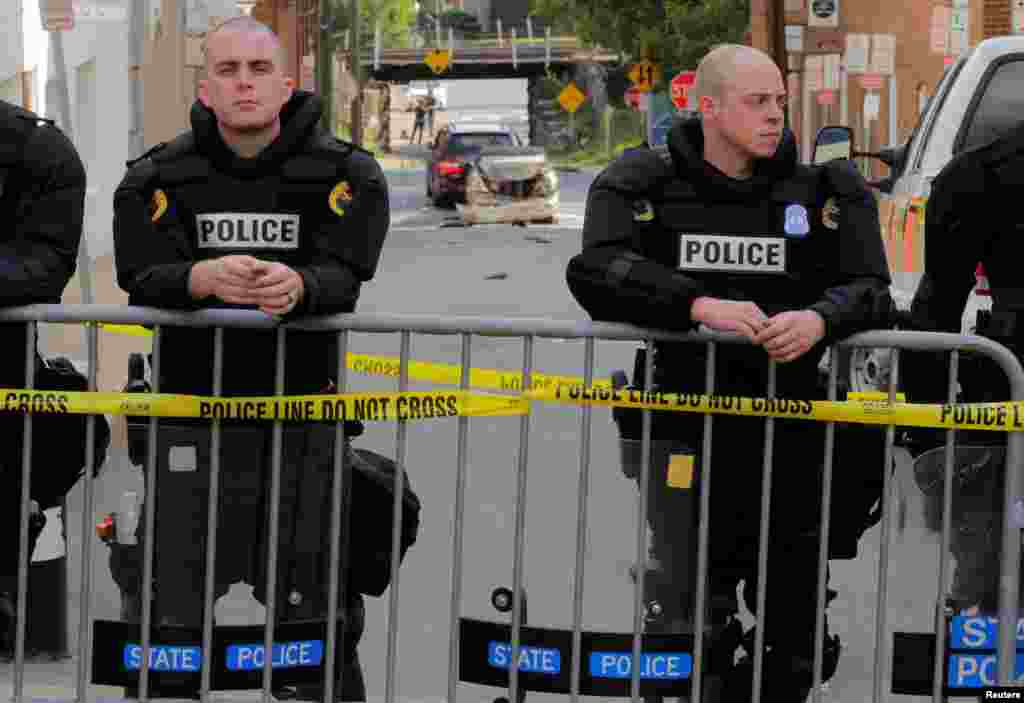 Virginia State police stand guard at the crime scene where a vehicle plowed into a crowd of counter protesters and two other vehicles (rear) near the &quot;Unite the Right&quot; rally organized by white nationalists in Charlottesville, Aug. 12, 2017.