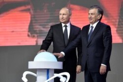 FILE - Russian President Vladimir Putin (L) and Uzbek President Shavkat Mirziyoyev, inaugurate the construction of a nuclear power plant, in Tashkent, Uzbekistan, Oct. 19, 2018.