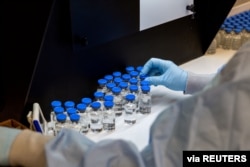 A lab technician inspects filled vials of remdesivir at a Gilead Sciences facility in La Verne, California, March 11, 2020.