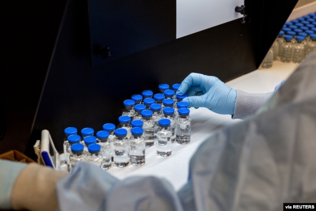 A lab technician inspects filled vials of remdesivir at a Gilead Sciences facility in La Verne, California, March 11, 2020.