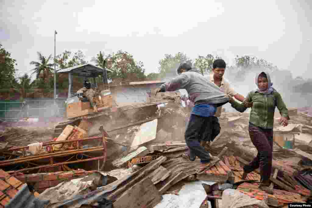 Jan. 24, 2009 - Phnom Penh, Cambodia. Residents flee a bulldozer as it charges into rubble of destroyed homes during the forced eviction of Dey Krahorm. &copy; Nicolas Axelrod / Ruom