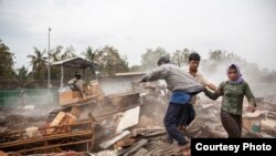 Jan. 24, 2009 - Phnom Penh, Cambodia. Residents flee a bulldozer as it charges into rubble of destroyed homes during the forced eviction of Dey Krahorm. The community of Dey Krahorm situated in central Phnom Penh was made up largely of artists and musicia