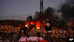 FILE - Civil Defense workers remove the body of Reuters videographer Issam Abdallah who was killed by Israeli shelling, at Alma al-Shaab border village with Israel, south Lebanon, Oct. 13, 2023. 