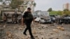 A police officer walks past the burnt cars of a humanitarian aid organization at the site of a Russian missile strike on an office building, amid the Russia-Ukraine conflict, in Kyiv, Ukraine, Sept. 2, 2024.