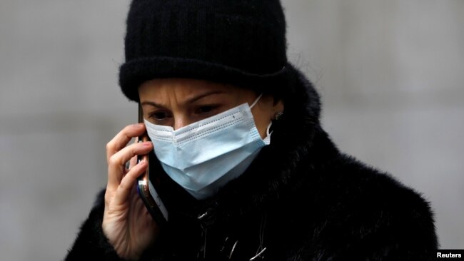 Las máscaras de cirugía, como la que usa la mujer en la foto, no protegen bien del coronavirus porque no ajustan en la cara.