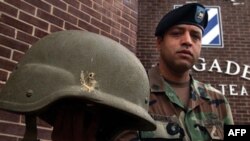 American soldier Jose Adorno holds a Kevlar helmet he was wearing when struck by a grenade explosion in Iraq several years ago