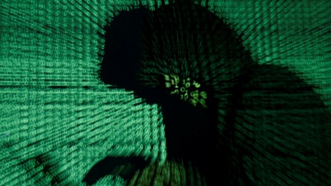 A man holds a laptop computer as cyber code is projected on him in this illustration picture taken on May 13, 2017.
