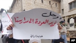 Demonstrators protest against Syria's President Bashar al-Assad in Zabadani, near Damascus January 13, 2012. The placard reads, "Go, we want to go back to our schools".