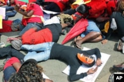 Masked sex workers lie down in protest in front of the Kenyan Supreme Court in Nairobi, March 6, 2012.