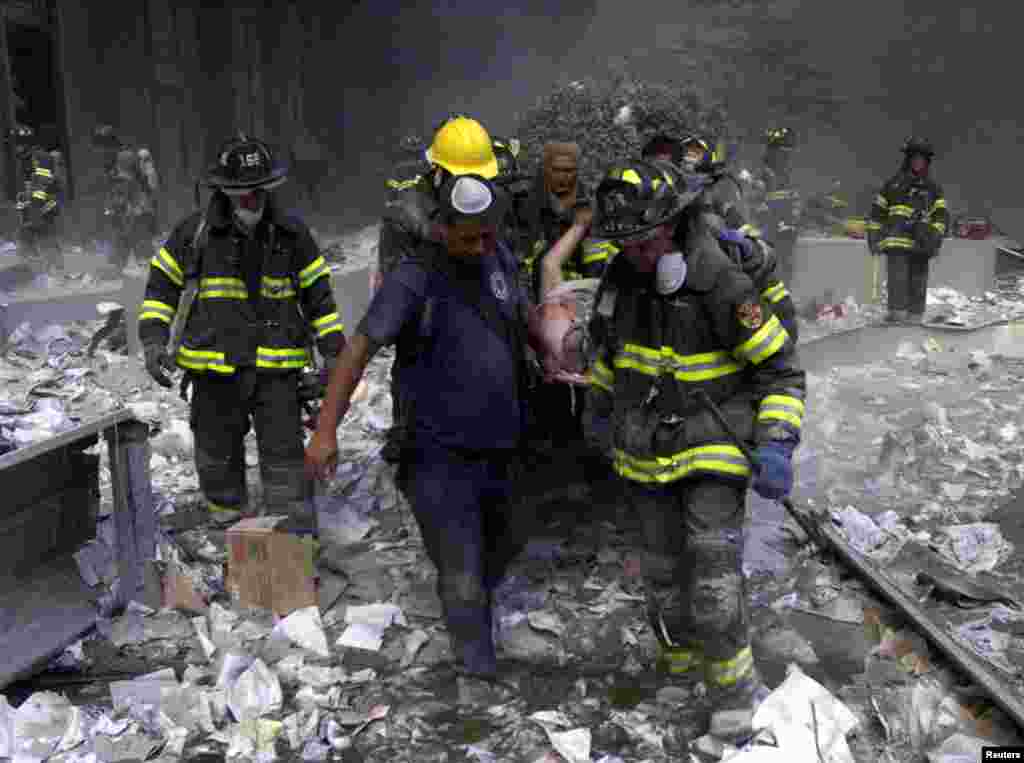 Firemen carry an injured man from the World Trade Center after both towers collapsed.
