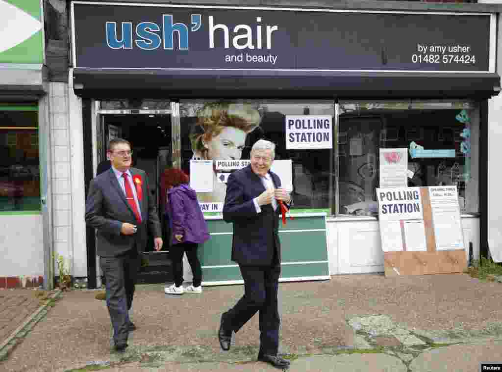 Former Labor Party member Alan Johnson (right) leaves a hair salon that is also a polling station during the election, in Hull, May 7, 2015.