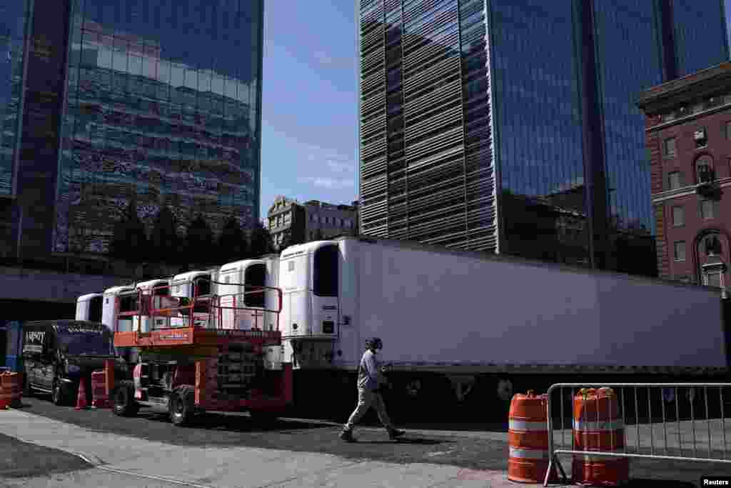 Un trabajador pasa junto a los camiones congeladores para almacenar cadáveres, parte de una morgue improvisada detrás de un hospital, durante el brote de la enfermedad por coronavirus, en el distrito de Manhattan, de la ciudad de Nueva York, Nueva York, el 26 de marzo de 2020.&nbsp;