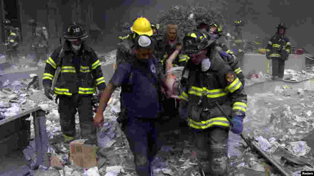 Des pompiers transportent un blessé du World Trade Center après l&rsquo;effondrement de deux tours jumelles touchées par des avions détournés par un commando à New York, 11 septembre 2001.