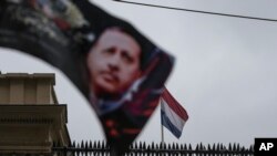 A banner with a picture of Turkish President Recep Tayyip Erdogan, is waved by protesters outside the Dutch consulate in Istanbul, March 12, 2017.