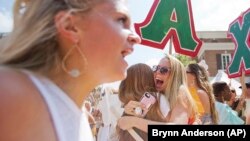 FILE - Alpha Chi Omega member Kaytlyn Carlson, right, hugs a new member of the sorority during the University of Alabama Bid Day, Saturday, August 19, 2017, in Tuscaloosa, Alabama.