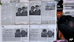 FILE-A man looks at morning newspapers which published condolence messages for two victims of Titan submersible incident, Shahzada Dawood and his son Suleman Dawood, at a roadside stall, in Islamabad, Pakistan, June 27, 2023.