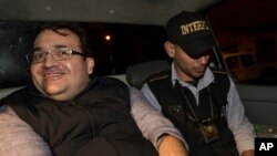Mexico's former Veracruz state Gov. Javier Duarte, left, is escorted by an agent of the local Interpol office inside a police car as they arrive at Guatemala City, early Sunday, April 16, 2017.