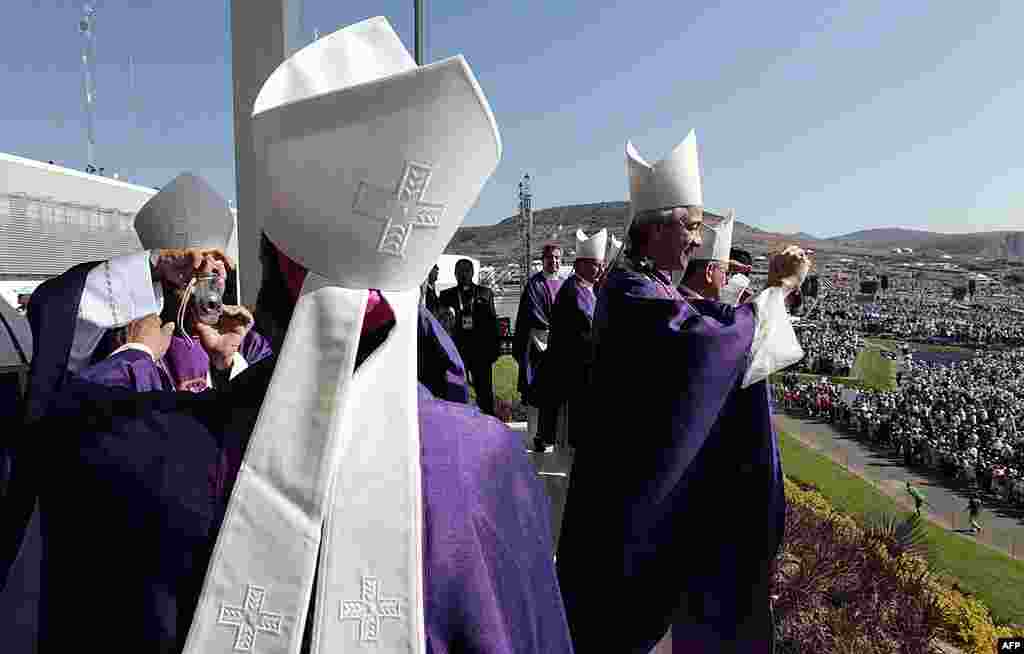 Prelates take pictures of each other and the crowd of faithful gathered at the Parque del Bicentenario as they wait for the arrival of Pope Benedict for a Mass near Silao, Mexico, March 25, 2012. (AP)