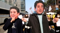 College students wearing masks of Japanese Prime Minister Shinzo Abe march toward Japanese embassy during a rally to mark the centennial of the March First Independence Movement Day against Japanese colonial rule (1910-45), in Seoul, South Korea, March 1, 2019.