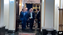 In this photo released by the Atomic Energy Organization of Iran, International Atomic Energy Agency Director General Rafael Mariano Grossi, right, is welcomed by deputy chief of Atomic Energy Organization of Iran, Behrouz Kamalvandi in Tehran, Iran, Nov. 13, 2024. 