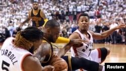 LeBron James (23) de Cavaliers et CAN Toronto, Ontario, bataillent pour le ballon sous la garde des Kyle Lowry (7) Raptors de Toronto et de l'attaquant DeMarre Carroll (5) lors du quatrième match de la finale de conférence Est de la NBA Playoffs au Centre Air Canada. Les Raptors ont gagné 105-99. Credit: Dan Hamilton-USA TODAY Sport - RTSFMEL