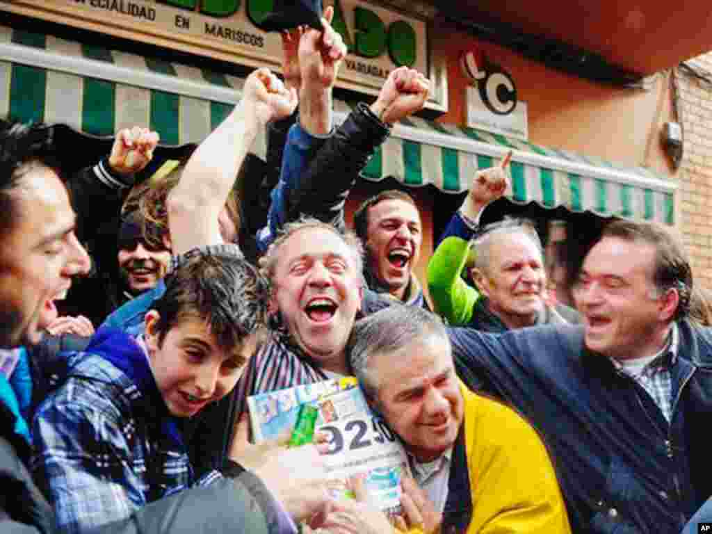 People celebrate after winning a portion of the main prize of Spain's Christmas lottery in Palleja, Spain, Wednesday, Dec. 22, 2010. Spain's beloved Christmas lottery known as "El Gordo" (The Fat One) spread euro2.3 billion ($3 billion) in holiday cheer W