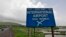 A signboard is pictured at the proposed site of Navi Mumbai airport, about 45 km (27 miles) east of Mumbai, August 8, 2012. 