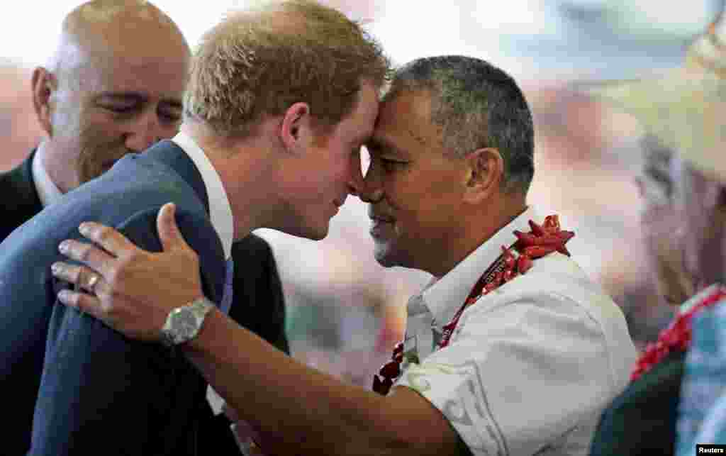 Britain&#39;s Prince Harry (L) exchanges a hongi (traditional Maori greeting) with a staff member at the Southern Cross Campus School in Auckland, New Zealand.