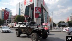 A special police vehicle drives in Kizilay Square with a poster of Turkey's President Recep Tayyip Erdogan in the background in Ankara, Turkey, Thursday, July 21, 2016. Turkey's Parliament approved a crackdown following an attempted coup last week. (AP Photo/Burhan Ozbilici)