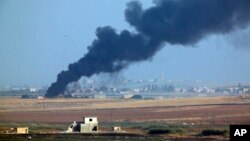 In this photo taken from the Turkish side of the border between Turkey and Syria, in Akcakale, Sanliurfa province, southeastern Turkey, smoke billows from a fire inside Syria during bombardment by Turkish forces, Oct. 9, 2019. 